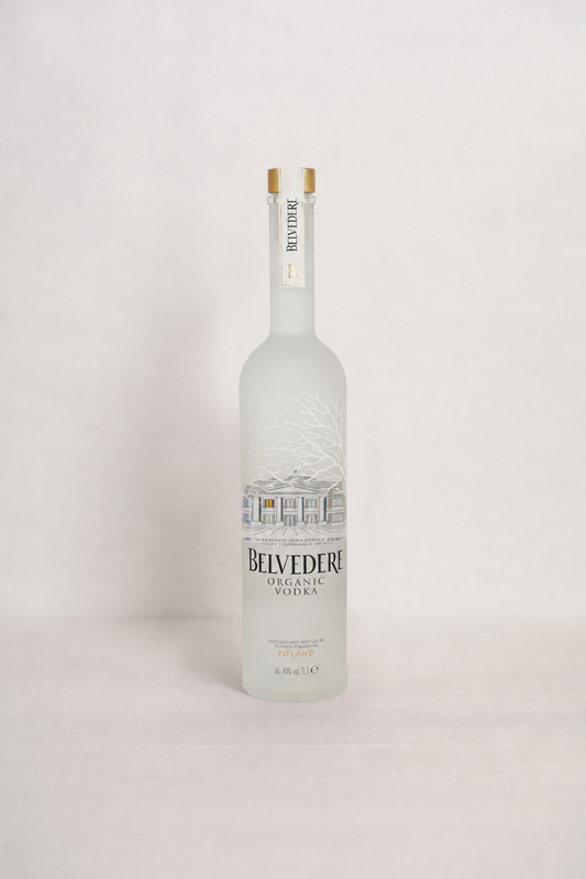Botella de Belvedere Organic Vodka, de vidrio blanco con relieve de ramas y etiqueta frontal.